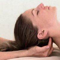 Young woman getting neck, head massage in therapy room. Male masseur therapist making chiropractic treatment with deep tissue after sport injury or scoliosis problem. Alternative medicine